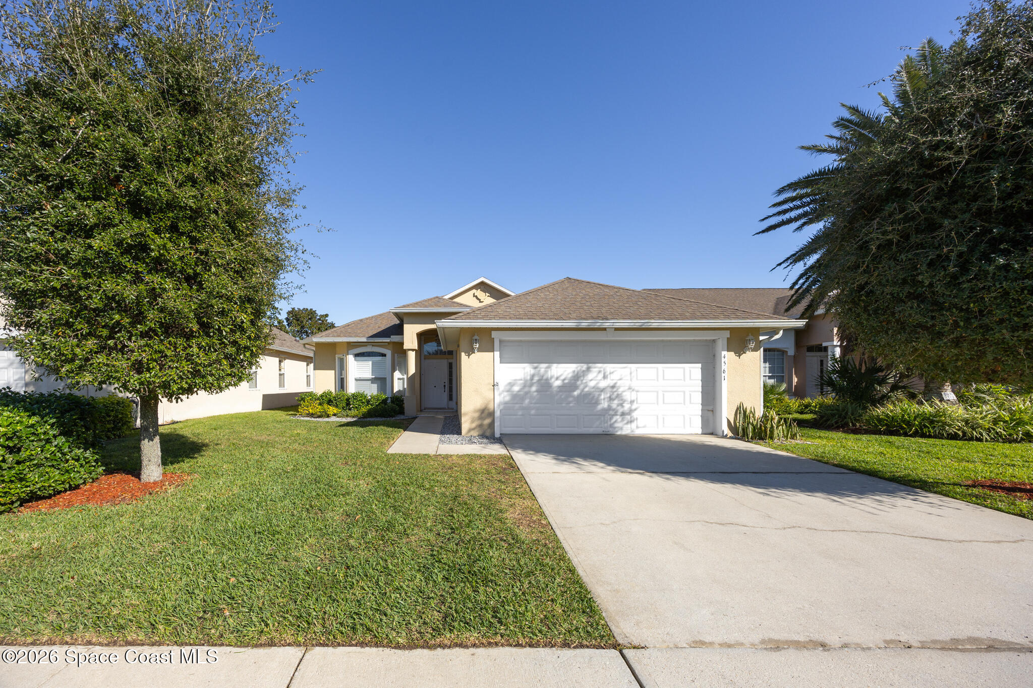 Undisclosed Address Melbourne, FL 32940 - Photo 2 of 26 a front view of a house with a yard and garage