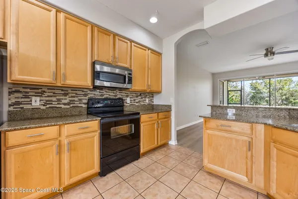 a kitchen with granite countertop cabinets stainless steel appliances a sink and a window