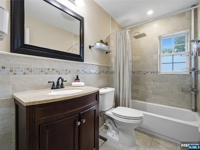 a bathroom with a toilet a sink a mirror a bathtub and shower