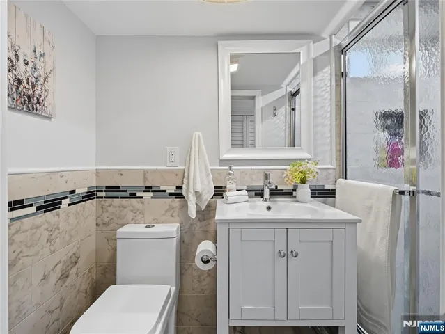 a bathroom with a granite countertop toilet sink and mirror