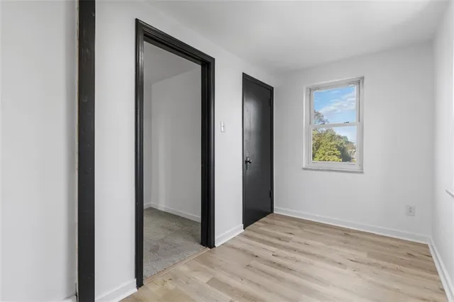 a view of an empty room with closet and a window