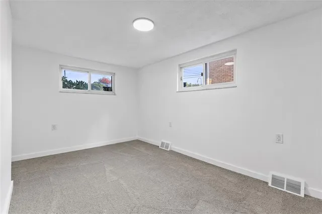 an empty room with a painting on the wall