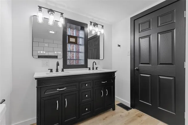 a bathroom with a double vanity sink and mirror