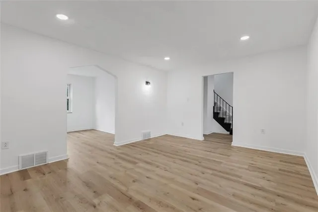 a view of an empty room with wooden floor