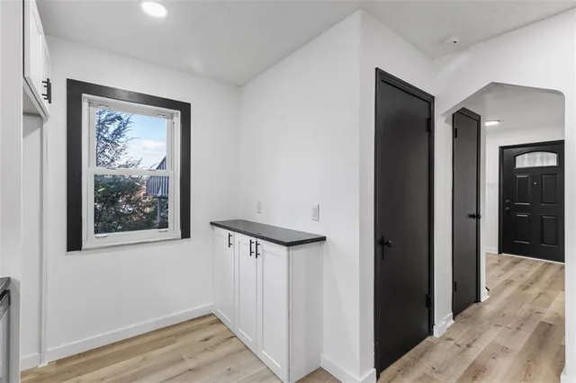 a view of a hallway with wooden floor and closet