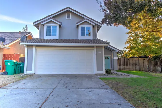 a front view of house with yard and trees