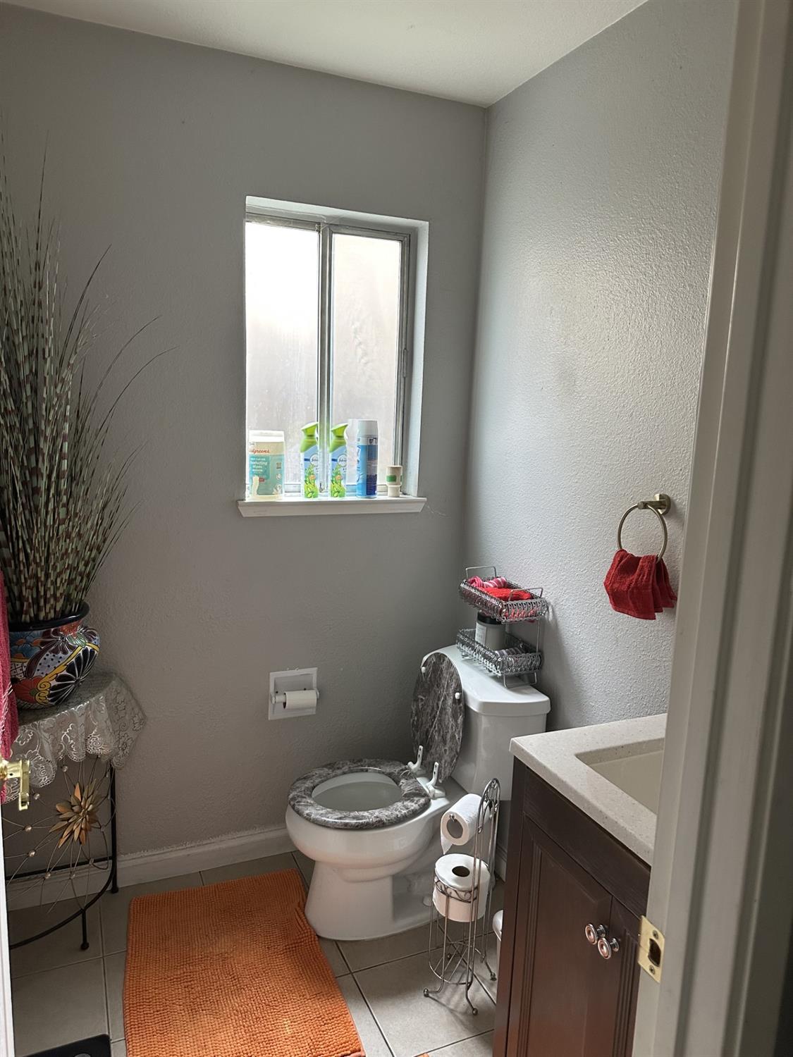 5723 Larcom Lane Stockton, CA 95210 - Photo 14 of 22 a white toilet sitting next to a bathroom sink and vanity
