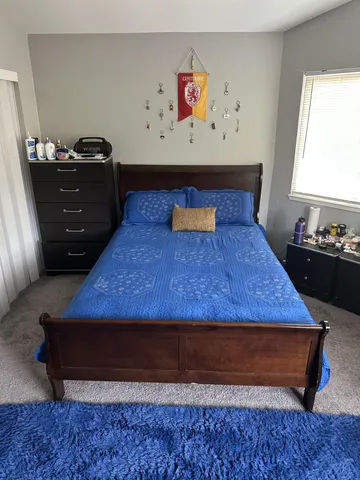 a bed sitting in a bedroom next to a window