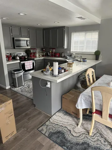 a kitchen with kitchen island granite countertop a sink cabinets and stainless steel appliances