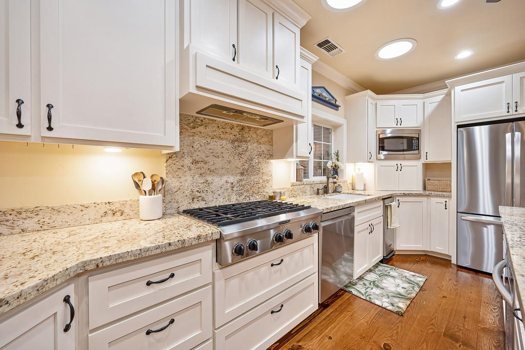 3557 Val Verde Road Loomis, CA 95650 - Photo 15 of 71 a kitchen with granite countertop kitchen island stainless steel appliances a stove refrigerator sink and cabinets