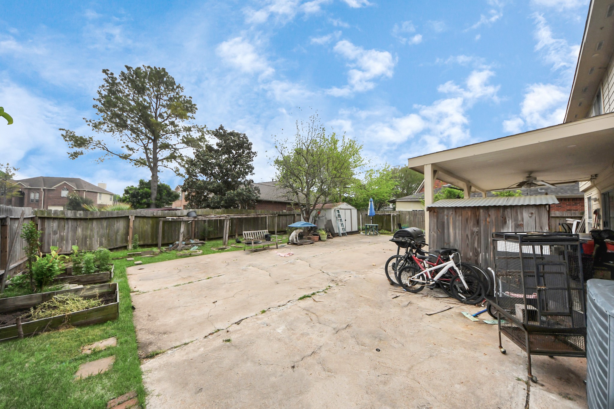 14119 Renn Road Houston, TX 77083 - Photo 33 of 43 a view of backyard with wheel chair potted plants and wooden fence