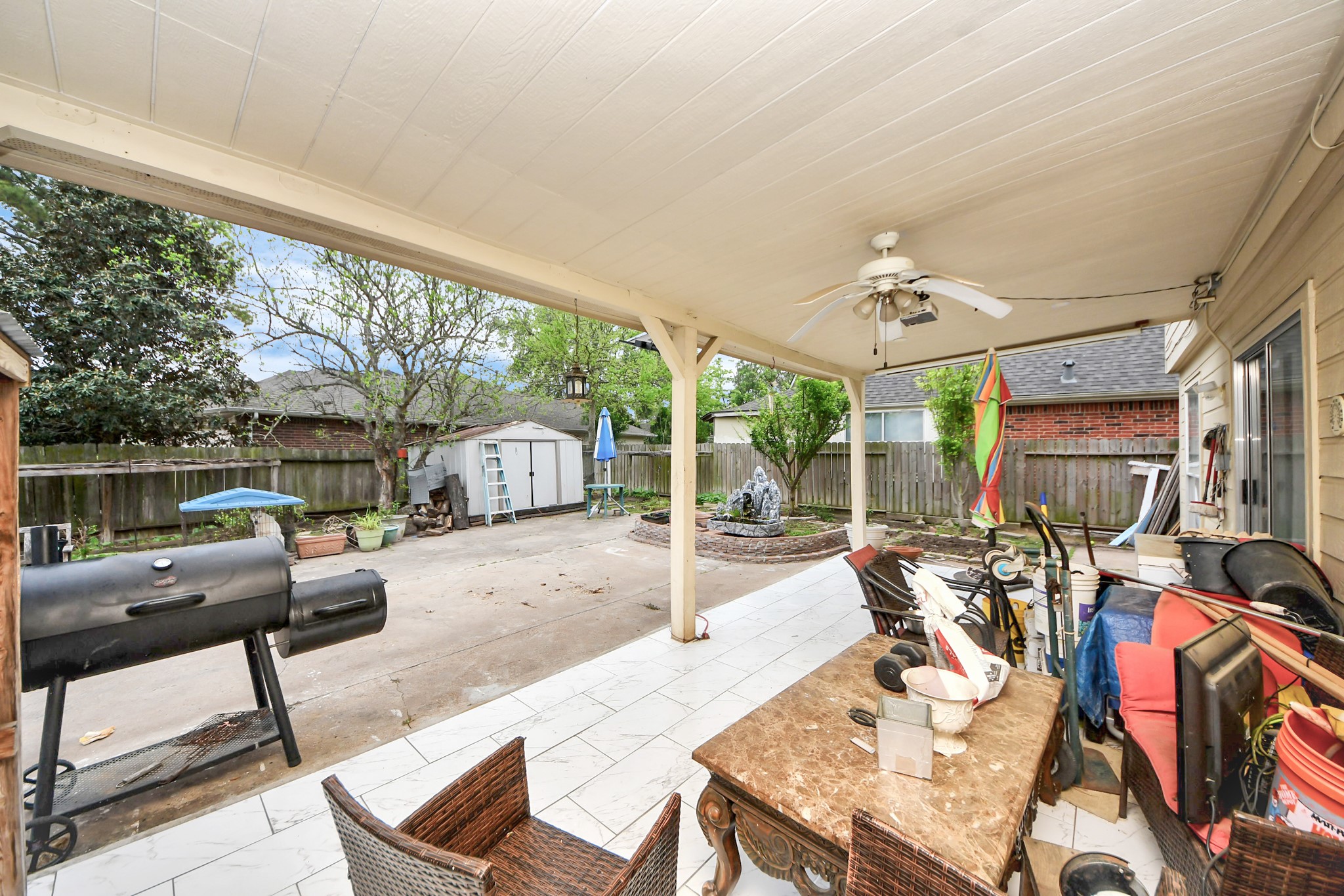 14119 Renn Road Houston, TX 77083 - Photo 35 of 43 a view of a patio with table and chairs potted plants and large tree