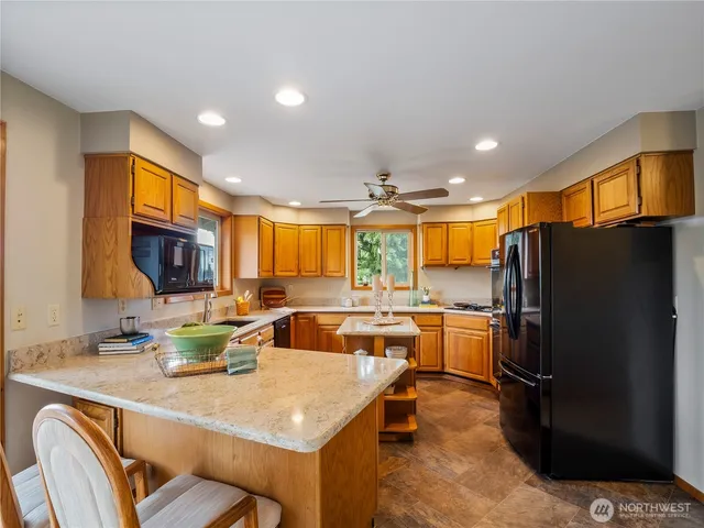 a kitchen with stainless steel appliances granite countertop a sink a stove and a refrigerator