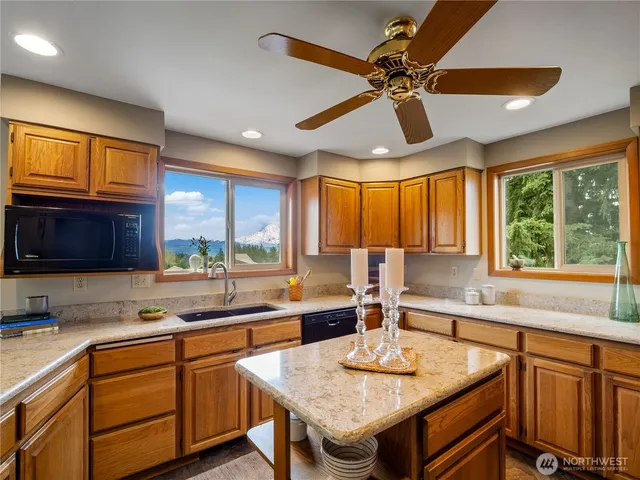 a kitchen with stainless steel appliances granite countertop a sink a stove and a refrigerator
