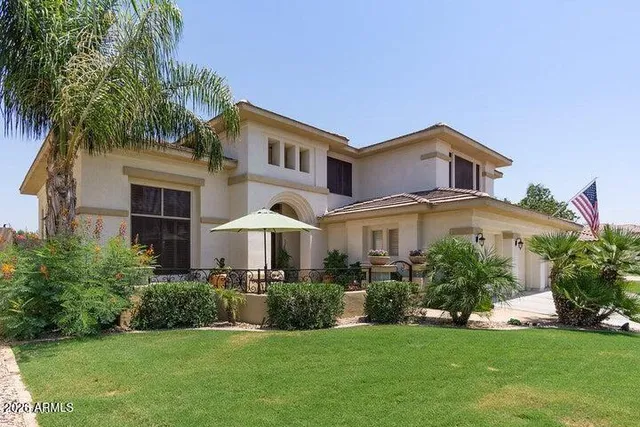 a front view of a house with a yard and potted plants