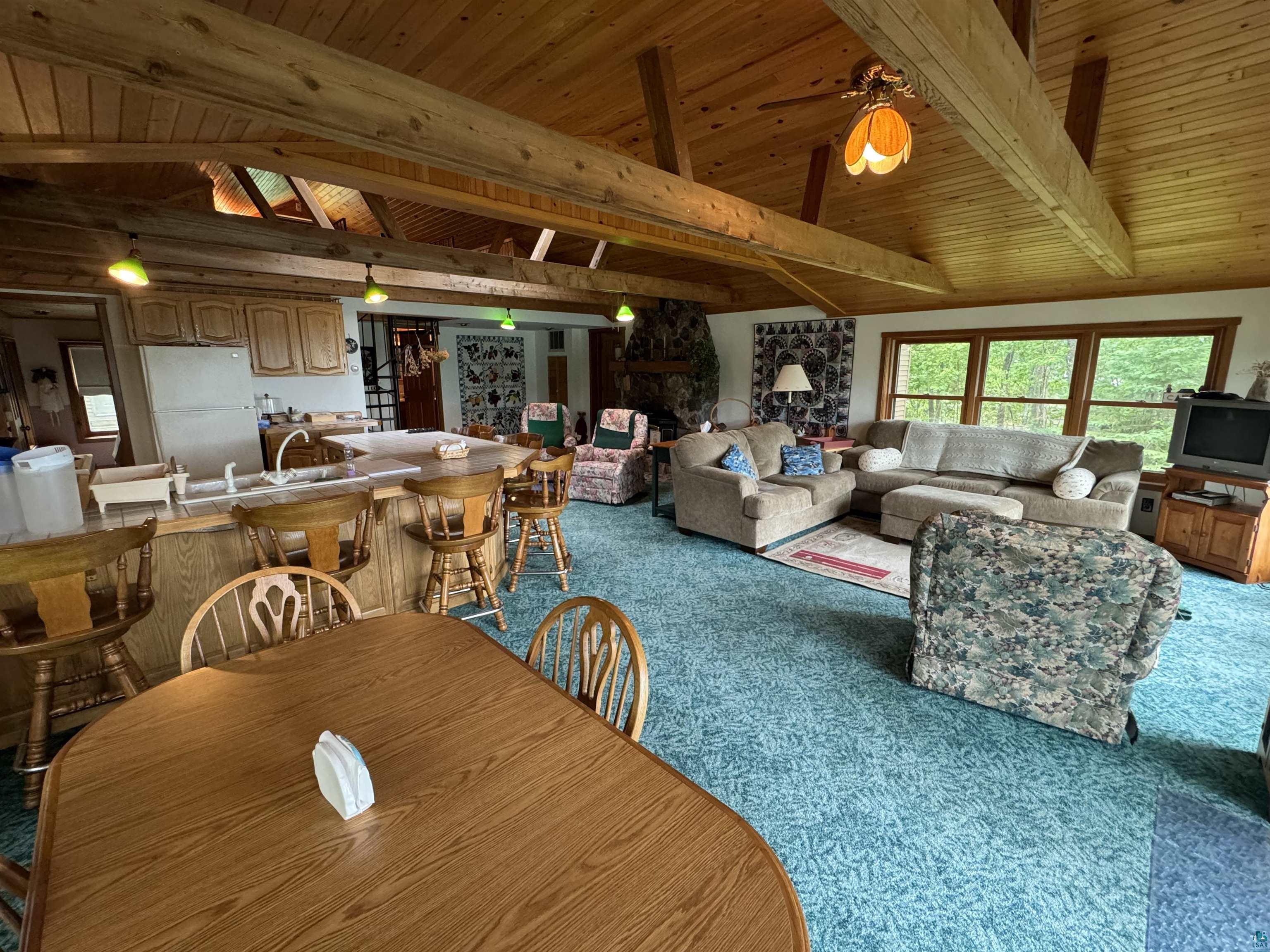 10690 Cedar Crest Road Iron River, WI 54847 - Photo 11 of 24 Dining space with carpet flooring, wood ceiling, ceiling fan, and lofted ceiling with beams