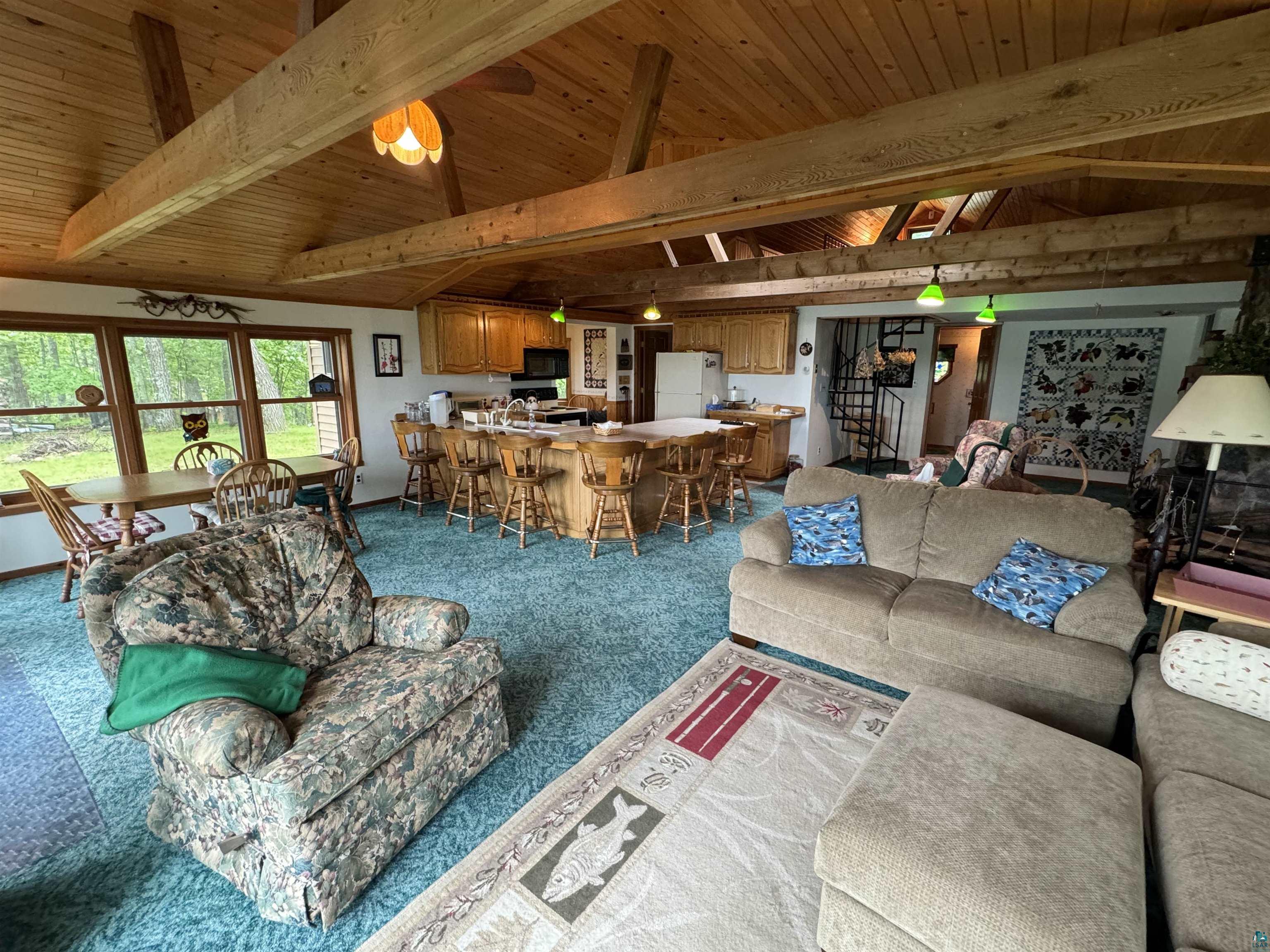 10690 Cedar Crest Road Iron River, WI 54847 - Photo 10 of 24 Carpeted living room featuring vaulted ceiling with beams and wooden ceiling