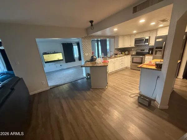 a view of kitchen with cabinets appliances and wooden floor