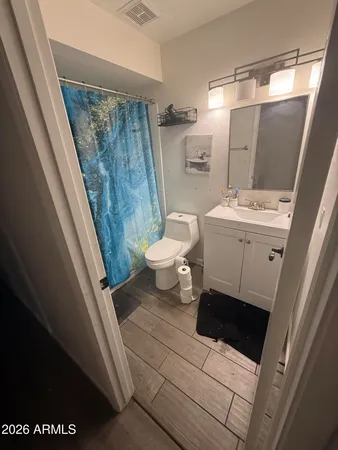 a bathroom with a sink a toilet a mirror and shower