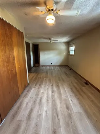 a view of an empty room and window chandelier fan