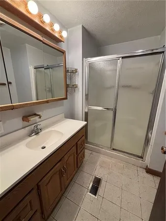 a bathroom with a double vanity sink a mirror and a shower