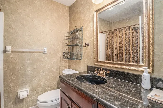 a bathroom with a granite countertop sink toilet and shower