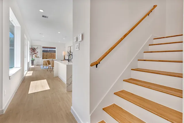 a bedroom with a large bed a chandelier and a potted plant