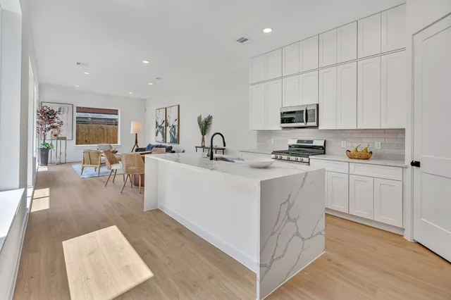 a kitchen with white cabinets and stainless steel appliances