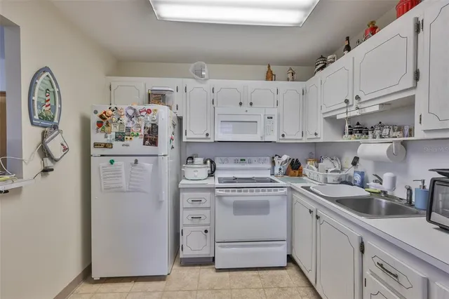 a kitchen with white cabinets and white appliances