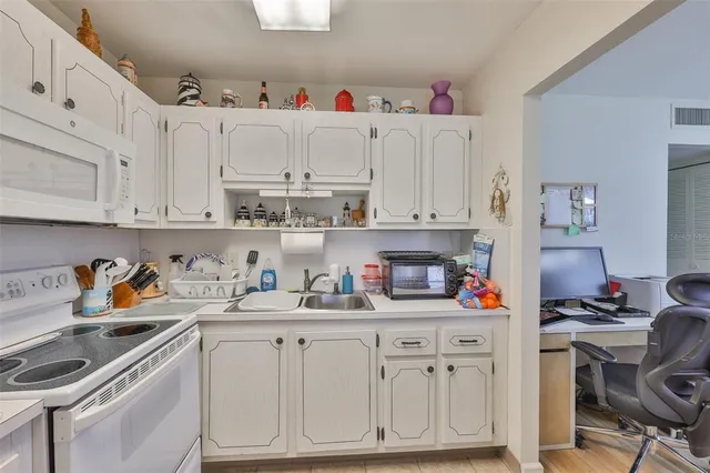 a kitchen with white cabinets and white appliances
