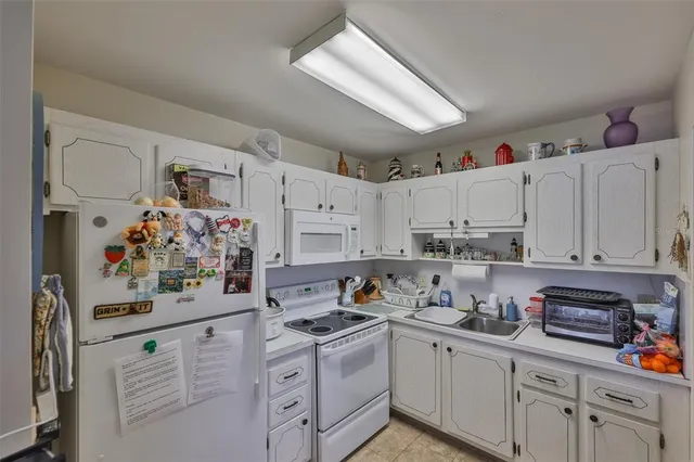 a kitchen with white cabinets and white appliances