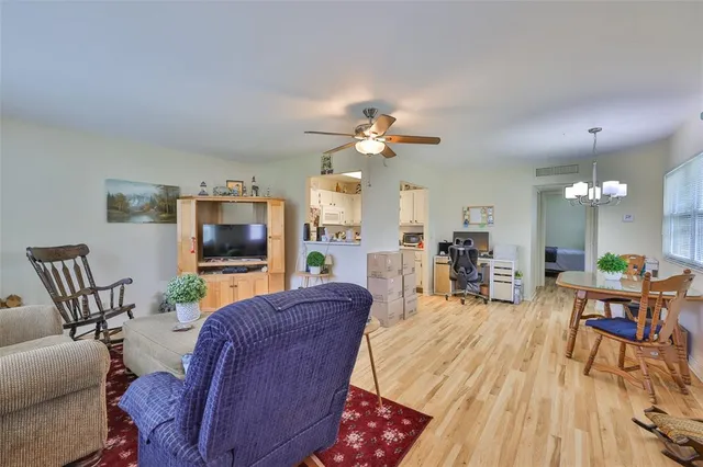 a living room with furniture a flat screen tv and kitchen view