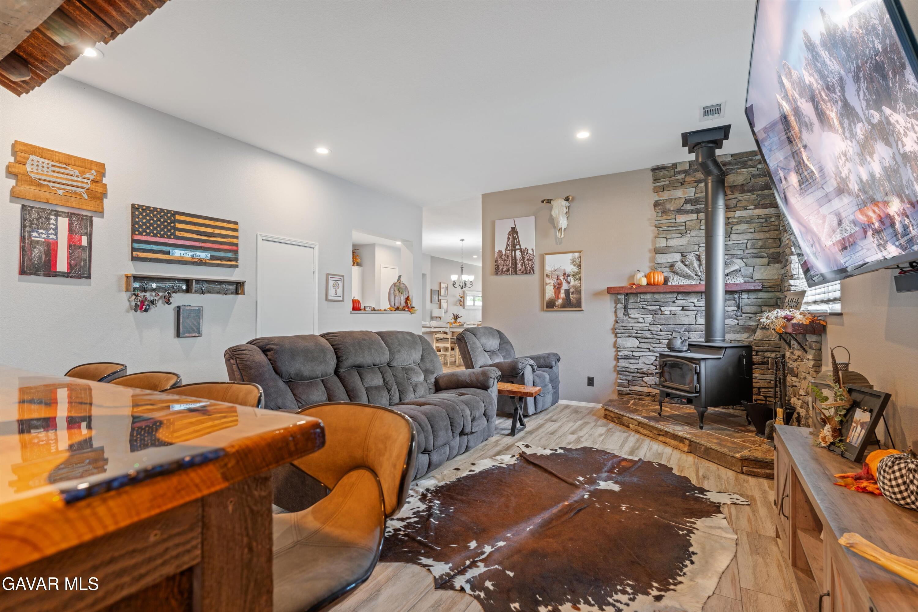 1413 Wild Olive Road Tehachapi, CA 93561 - Photo 21 of 29 a living room with furniture a fireplace and a painting