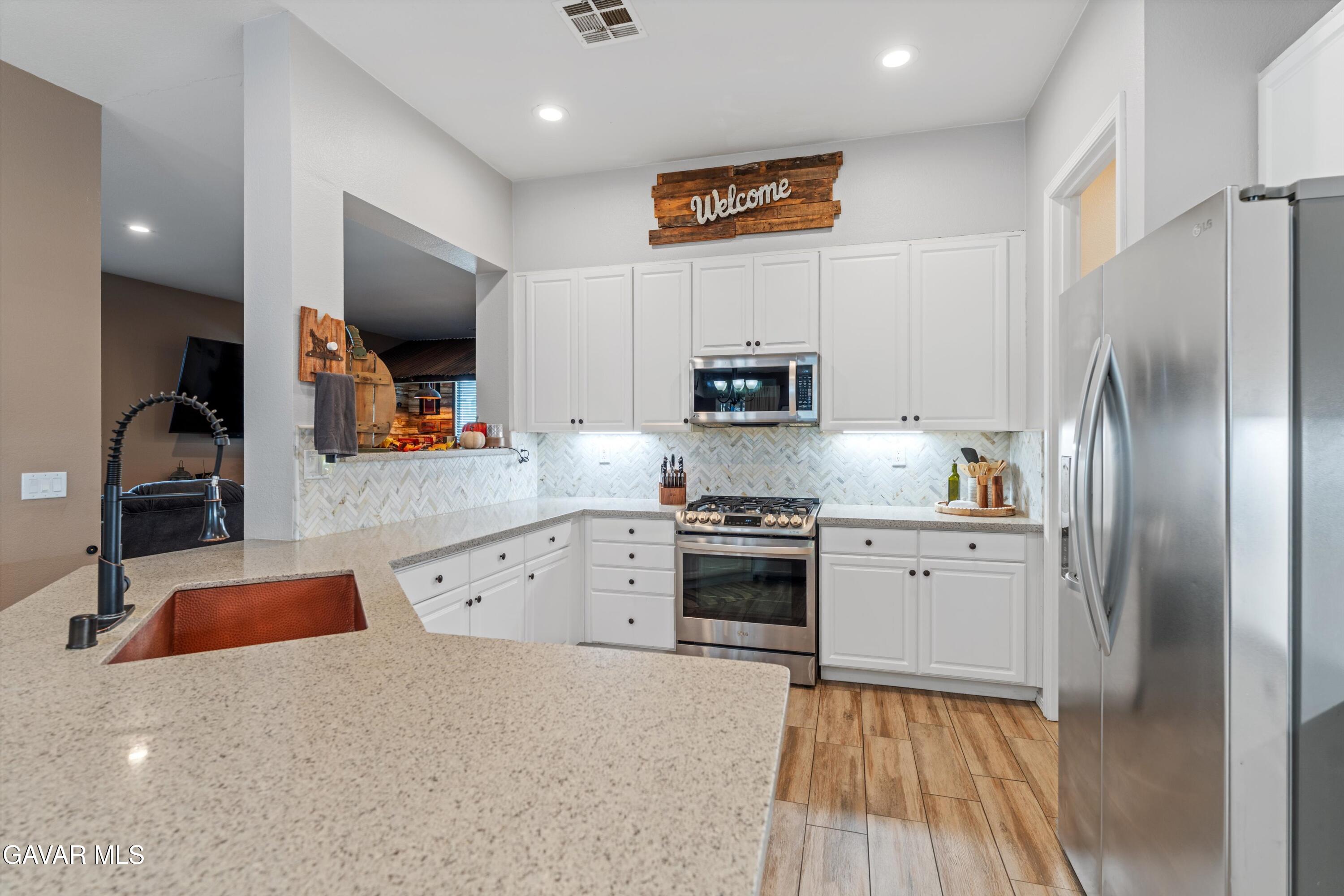 1413 Wild Olive Road Tehachapi, CA 93561 - Photo 23 of 29 a kitchen with stainless steel appliances a refrigerator sink and microwave