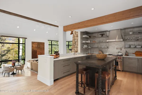 a kitchen with stainless steel appliances granite countertop a table chairs sink and cabinets