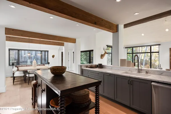 a kitchen with a table chairs and wooden floor