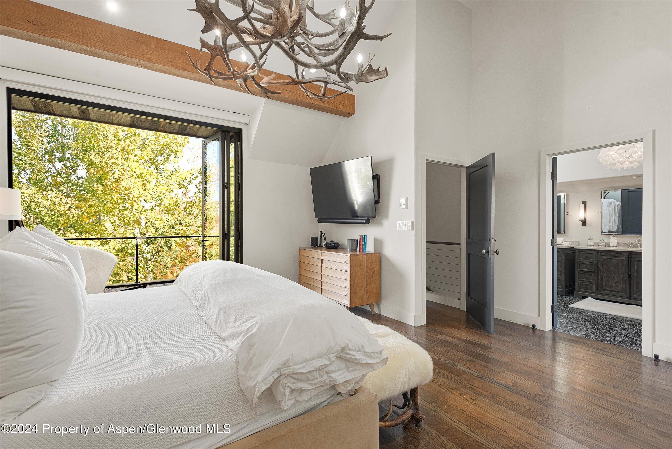 234 Bridge Lane Snowmass Village, CO 81615 - Photo 15 of 46 a bedroom with a bed and a flat screen tv