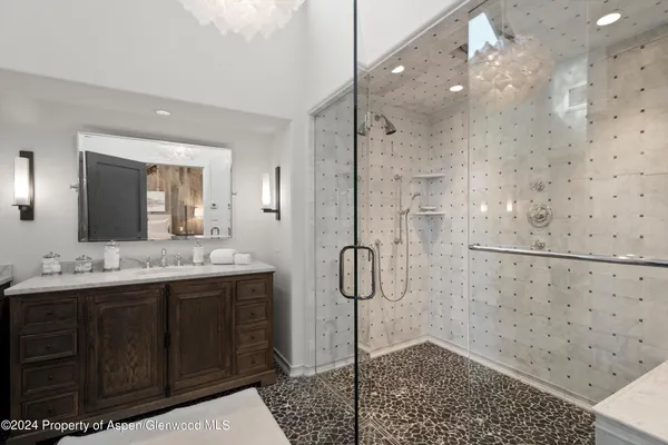 a bathroom with a double vanity sink mirror and shower