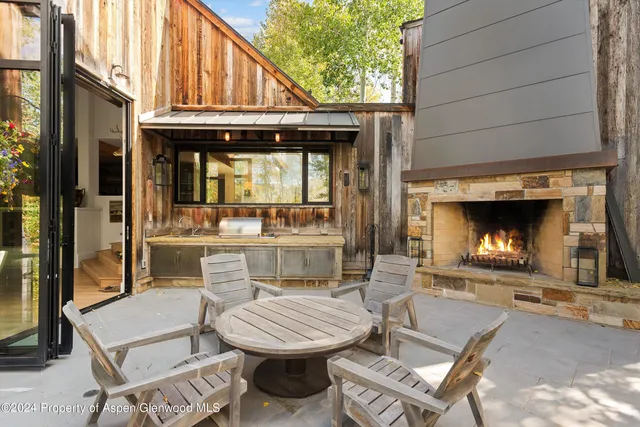 a view of a house with a barbeque grill and couches chairs