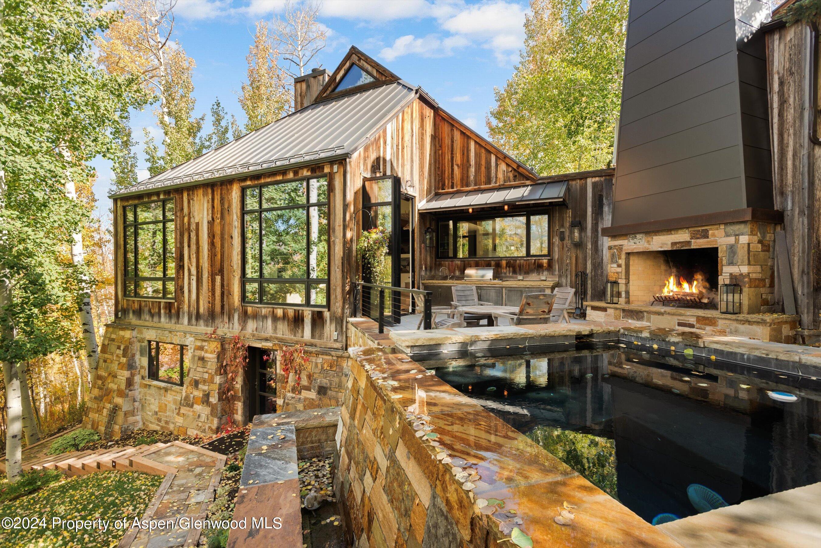 234 Bridge Lane Snowmass Village, CO 81615 - Photo 32 of 46 a view of a house with a barbeque grill and couches chairs