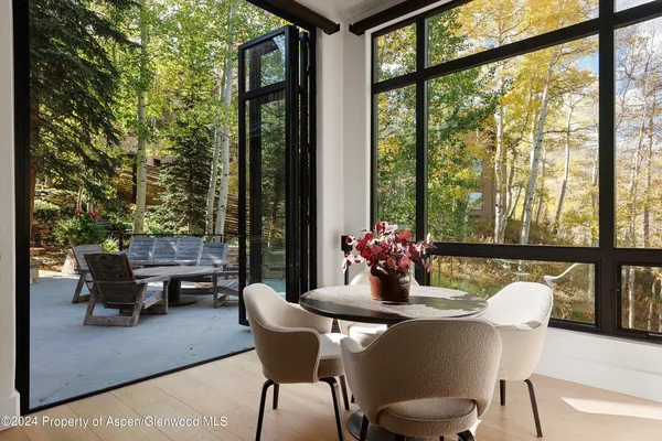 a dining room with furniture and a floor to ceiling window