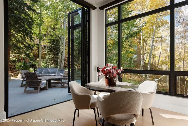a dining room with furniture and a floor to ceiling window