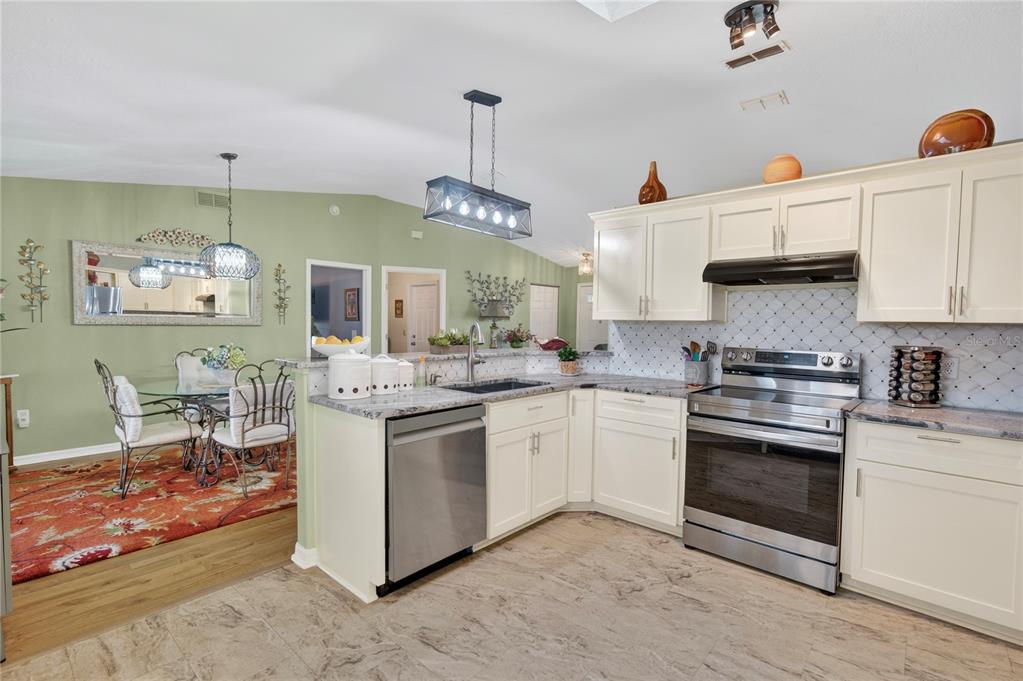 10447 Southwest 62nd Court Ocala, FL 34476 - Photo 17 of 58 a kitchen with stainless steel appliances granite countertop a stove and a sink