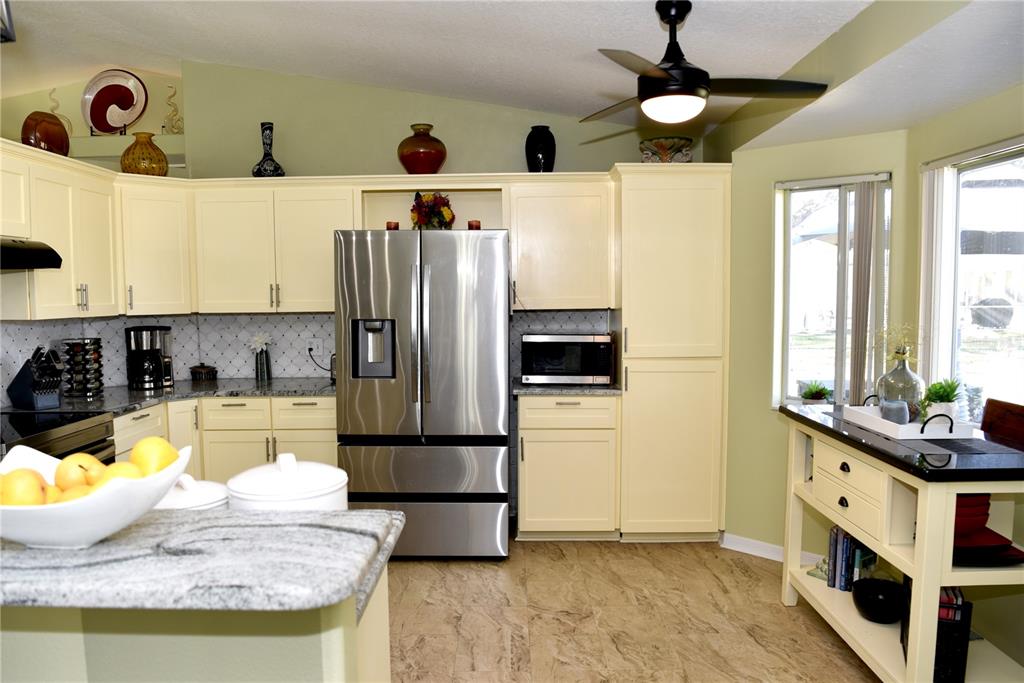 10447 Southwest 62nd Court Ocala, FL 34476 - Photo 18 of 58 a kitchen with stainless steel appliances granite countertop a sink a refrigerator and a stove