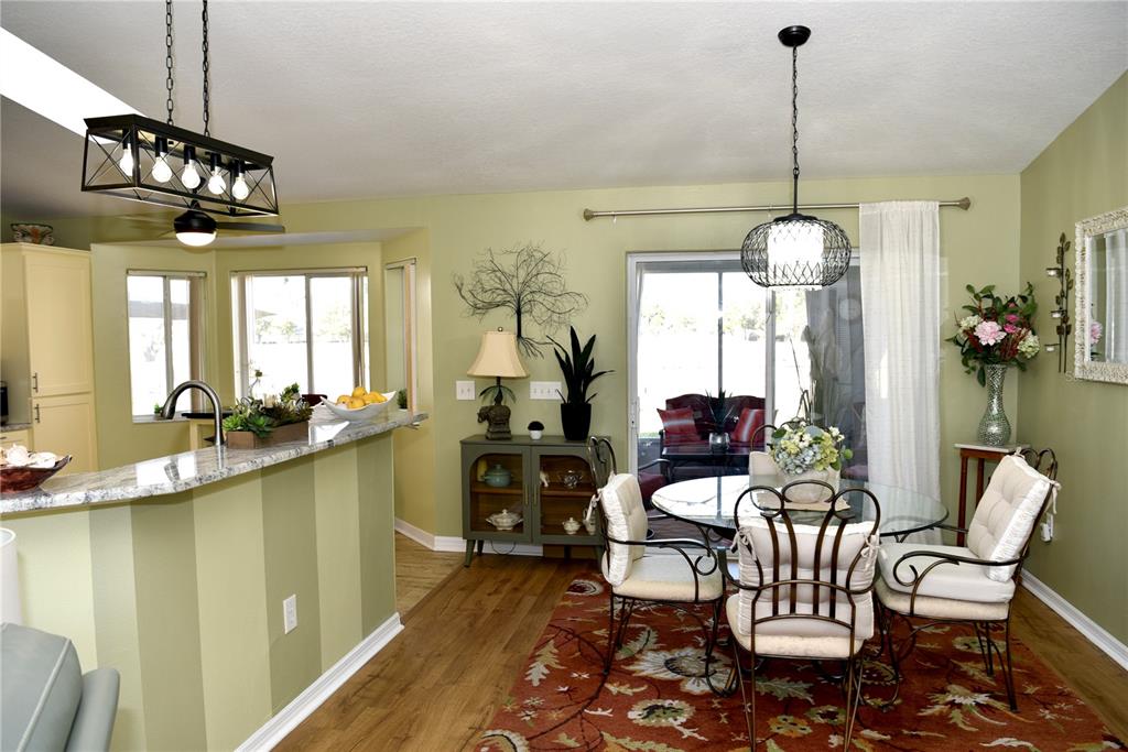 10447 Southwest 62nd Court Ocala, FL 34476 - Photo 30 of 58 a view of a dining room with furniture a chandelier and wooden floor