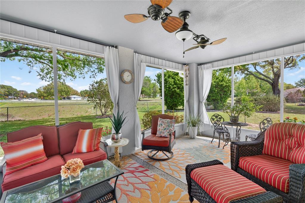 10447 Southwest 62nd Court Ocala, FL 34476 - Photo 40 of 58 a living room with patio furniture and a floor to ceiling window