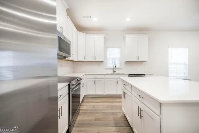 a kitchen with a sink stove and cabinets
