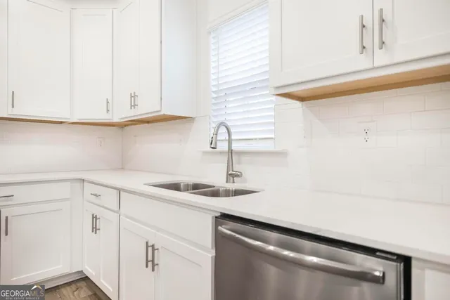 a kitchen with white cabinets and a sink