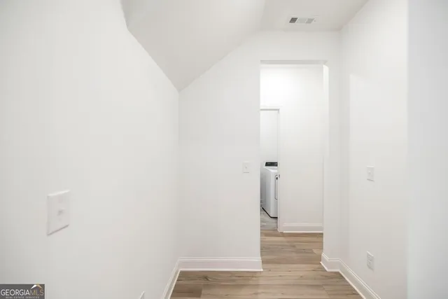 a view of a hallway with wooden floor