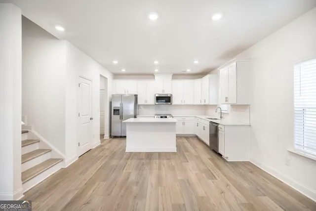 a large kitchen with a lot of counter space and a refrigerator